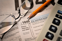 Tax forms with calculator and glasses